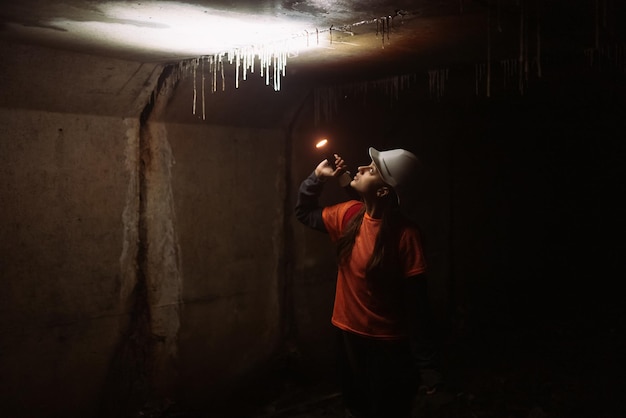 Female digger with flashlight explores the tunnel