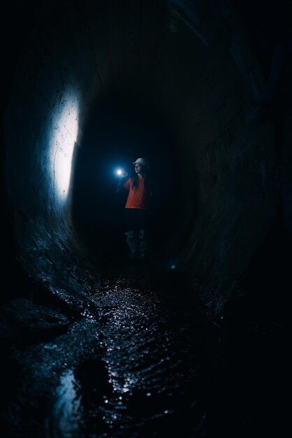 Female digger with flashlight explores the tunnel