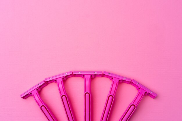 Photo female disposable razors on pink background top view