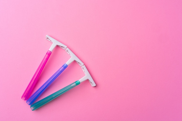 Female disposable razors on pink