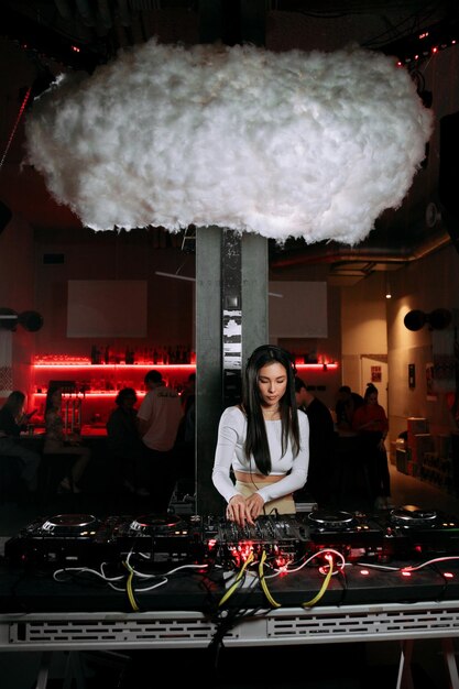 Female DJ plays music in a nightclub or other event using DJ equipment