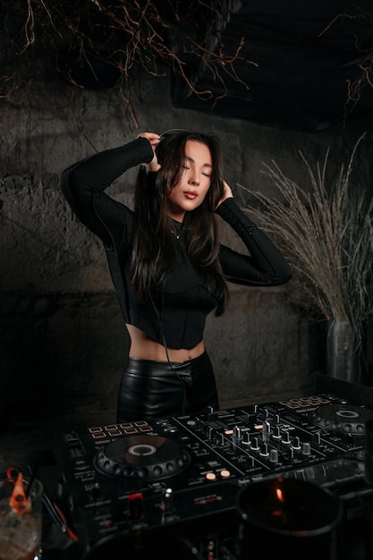 女性DJがナイトクラブや他のイベントでDJ機器を使って音楽を演奏する