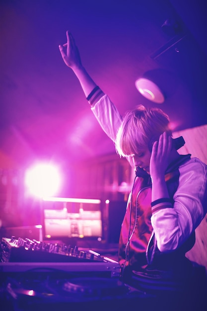 Foto dj femminile che agita la mano mentre suona musica al bar