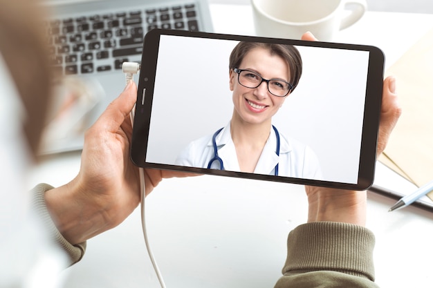 Female doctor advises patient online video chatting.