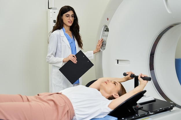 진단 평가를 위해 MRI 기계에서 환자를 보조하는 여성 의사