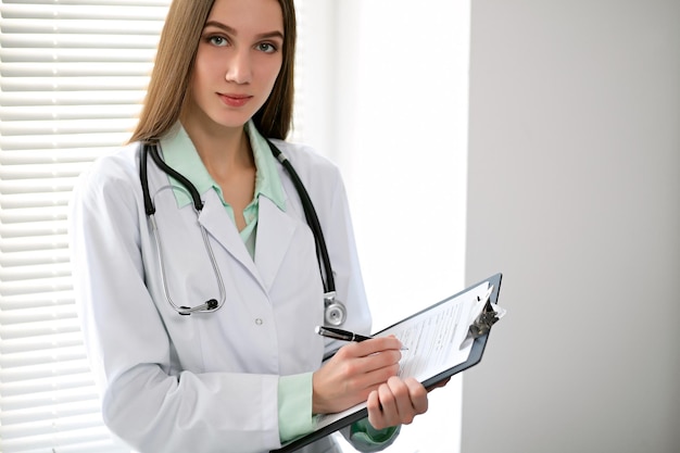 Female doctor brunette sitting at the table near the window in hospital