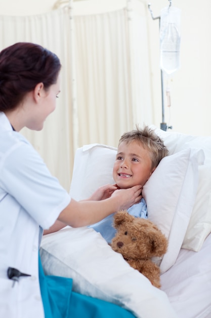 Female doctor checking child throat