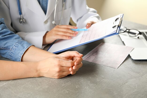 Female doctor checking electrocardiogram results with patient