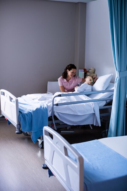 Female doctor consoling patient during visit in ward