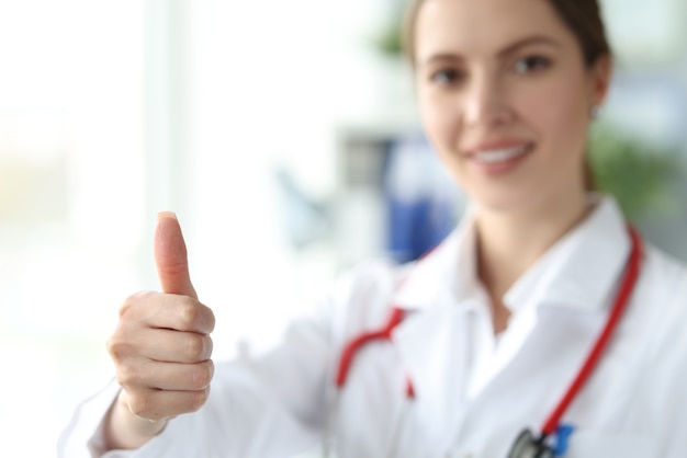 Female doctor demonstrating thumbs up gesture closeup