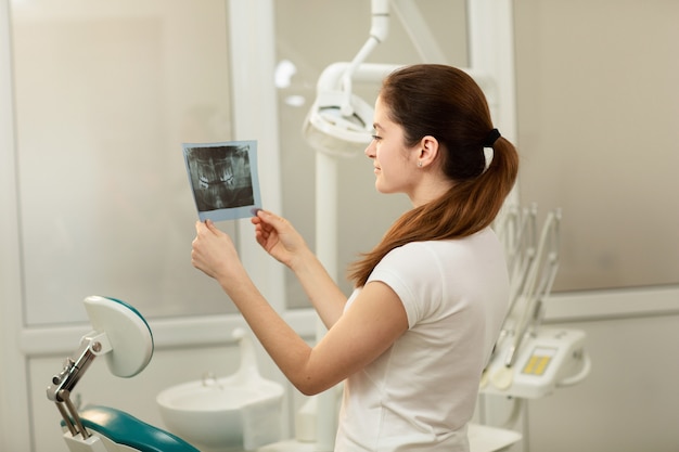 Female doctor or dentist looking at x-ray. Healthcare, medical and radiology concept