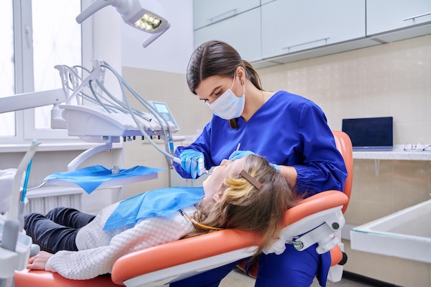 여성 의사 치과 의사는 마취를 사용하여 어린 소녀에게 치아를 치료
