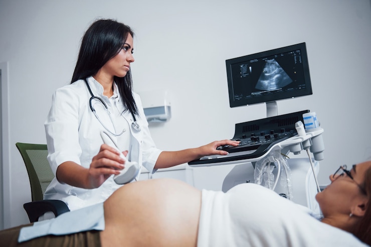 Photo female doctor does ultrasound for a pregnant woman in the hospital.