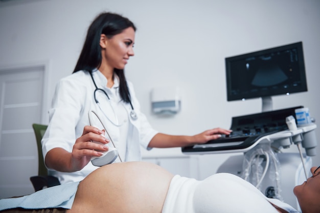 Female doctor does ultrasound for a pregnant woman in the hospital.