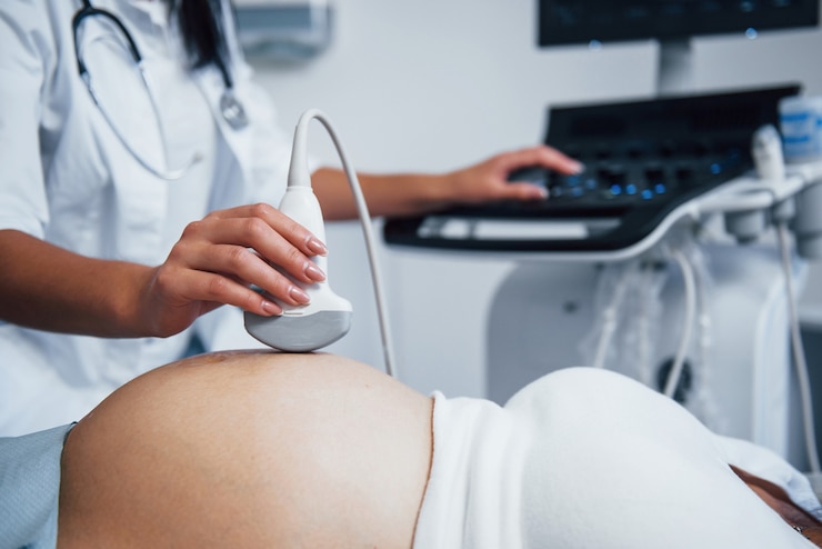 Photo female doctor does ultrasound for a pregnant woman in the hospital.