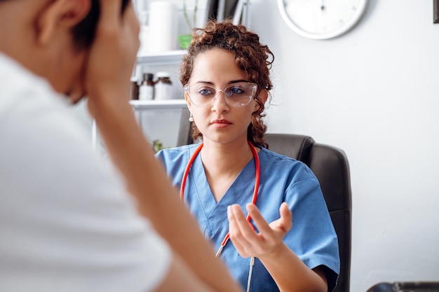 Female doctor doing an exam consultation with a sad patience