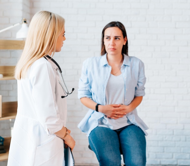 Female doctor examine the woman patient with stomach ache or period ache