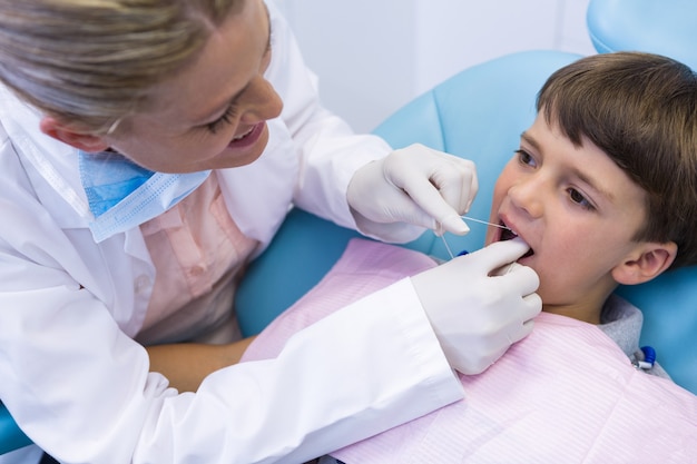 female doctor examing boy mouth