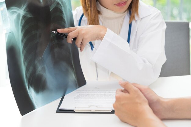 Female doctor examining about lungs with x-ray film