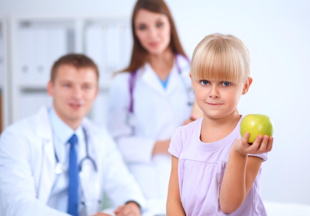 Female doctor examining child with stethoscope at surgery