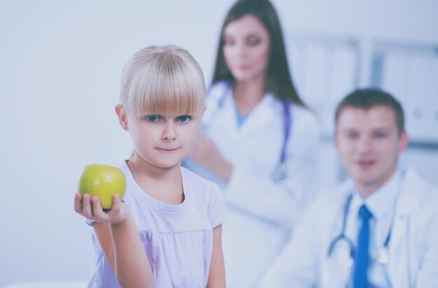 Female doctor examining child with stethoscope at surgery