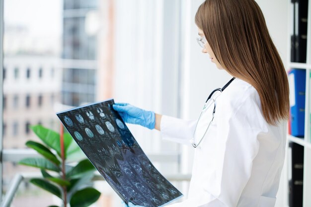 Female doctor examining MRI image in hospital