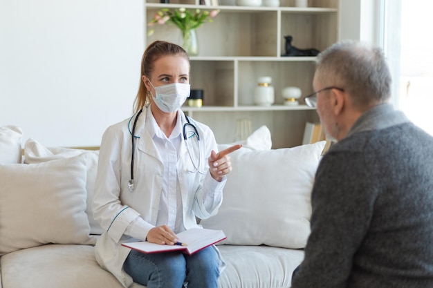 Female doctor examining older senior man in doctor office or at home old man patient and doctor have