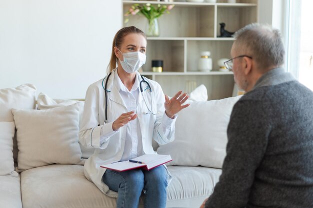 Female doctor examining older senior man in doctor office or at home old man patient and doctor have