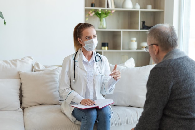 Female doctor examining older senior man in doctor office or at home old man patient and doctor have