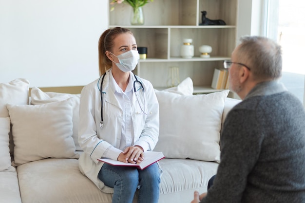 Female doctor examining older senior man in doctor office or at home old man patient and doctor have