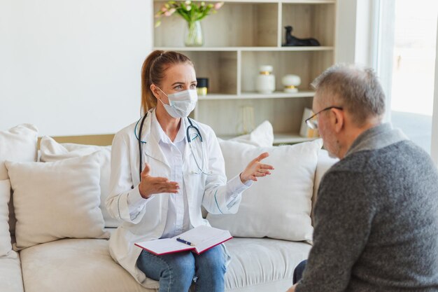 Photo female doctor examining older senior man in doctor office or at home old man patient and doctor have