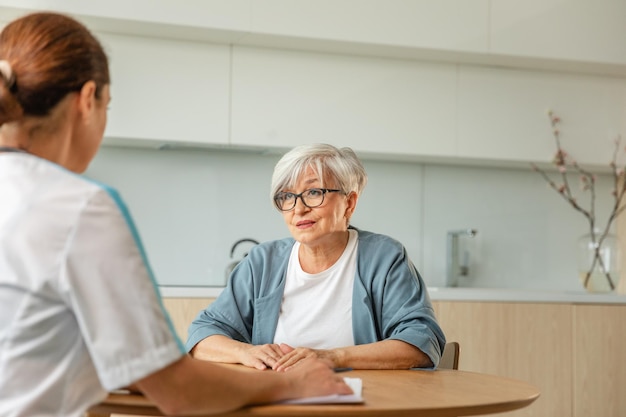 female doctor examining older senior woman in doctor office or at home old woman lady patient and