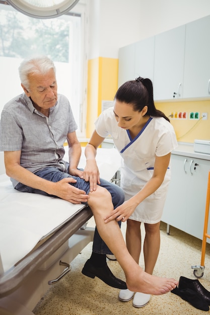 Female doctor examining patients knee