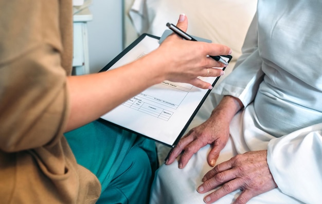 Female doctor filling out a questionnaire to a senior patient