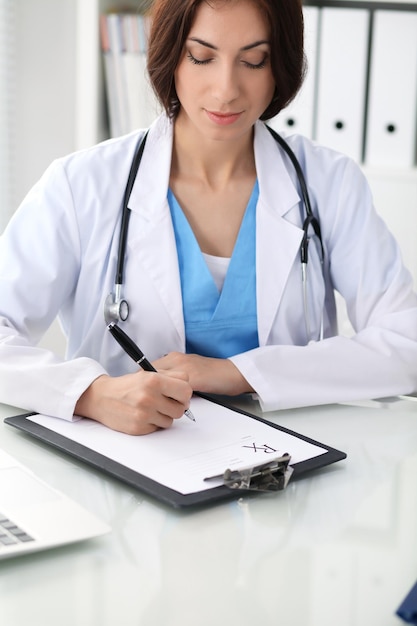 Female doctor filling up prescription Medicine healthcare and help concept