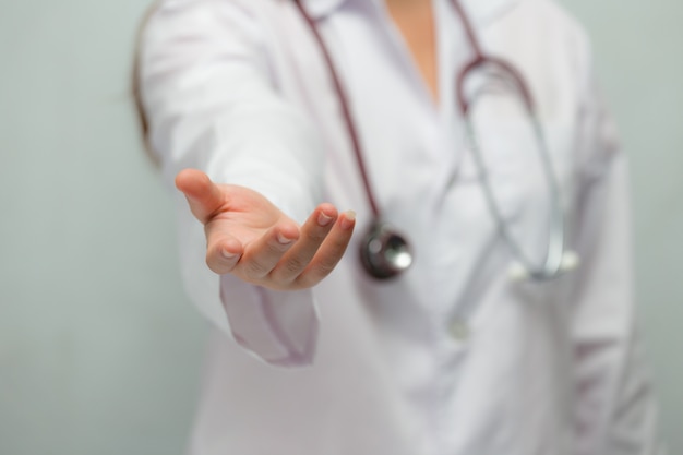 Female doctor giving her hand for helping to patient closeup.