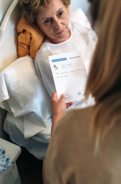 Female doctor giving a prescription to female senior patient