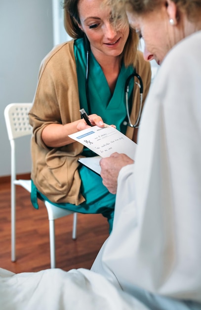 Female doctor giving a prescription to female senior patient