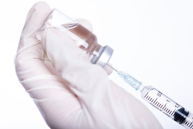 Female doctor hands holding syringe and vaccine. Healthcare And Medical concept.