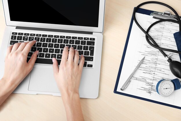 Female doctor hands typing on laptop