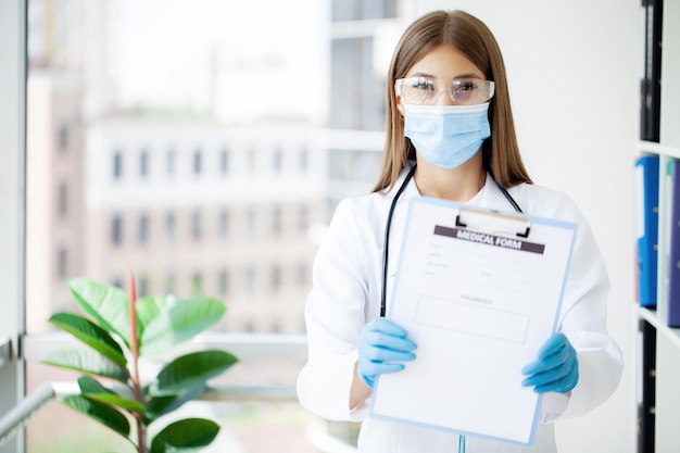 Female doctor hold clipboard pad and fill medical history\
list
