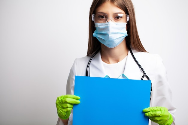 Female doctor holding a blank form with space for text.