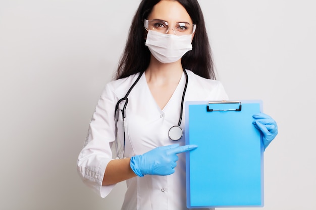 Female doctor holding a blank sheet of paper with space for text