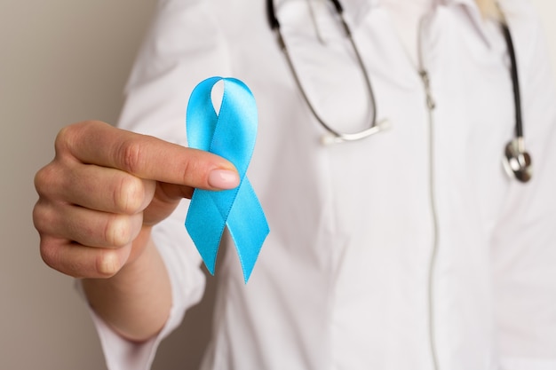 female doctor holding a blue ribbon in her hands 