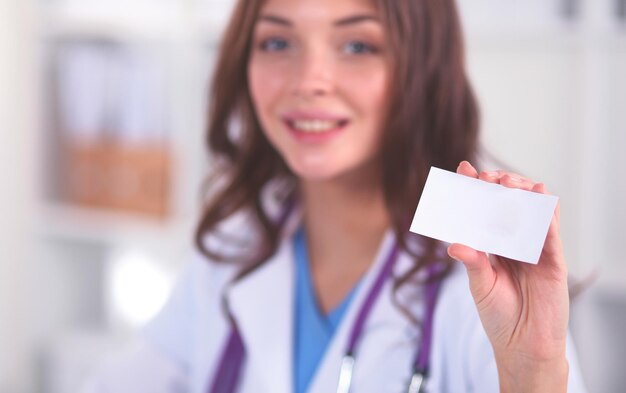 Photo female doctor holding an empty card isolated on white background