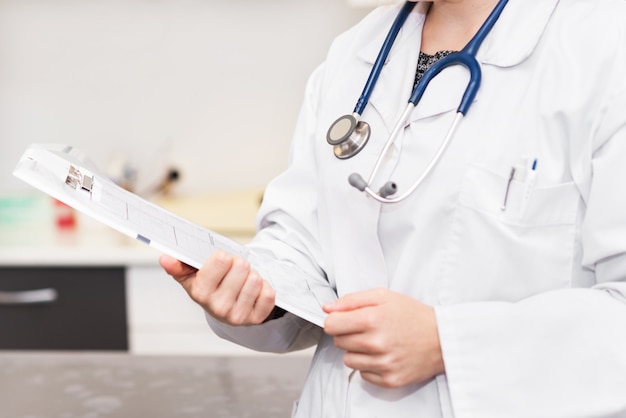 Female doctor holding patient chart clipboard