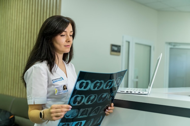 Female doctor holding a picture of a brain MRI workflow in diagnostic hospital Healthcare roentgen people and medicine concept