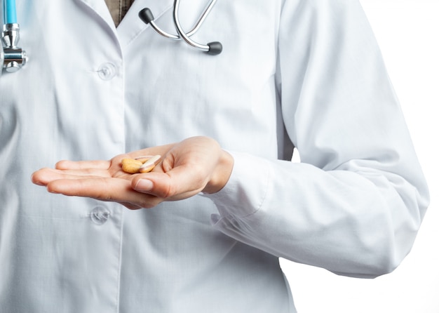 Female doctor holding a pills. Isolated on white.