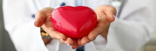 Photo female doctor holding red heart