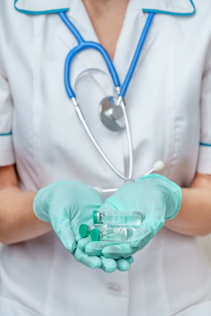 Female doctor holding tube with vaccine